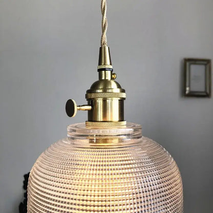 Modern brass textured glass led pendant light featuring a vintage brass finish and clear textured glass globe for kitchen use