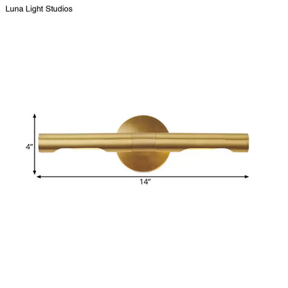 Modern brass tube vanity light featuring a sleek cylindrical bar and circular backplate wall sconce