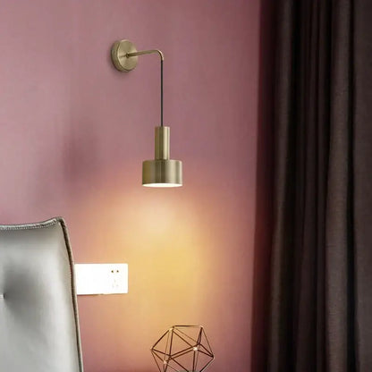 A sleek brass wall lamp with minimalist geometric design and cylindrical shade for modern living room decorbites brass wall lamp