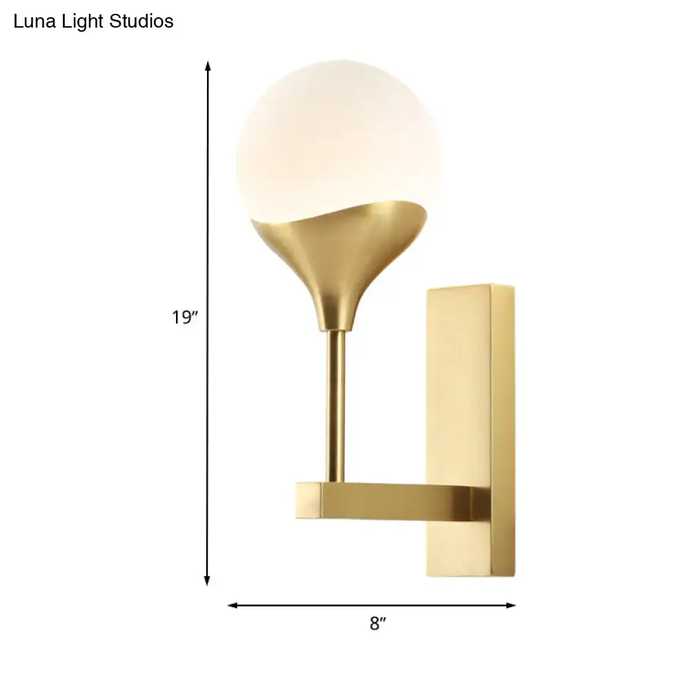 Modern brass wall lamp with a gold-toned wall light and cream frosted glass shade for bedroom use