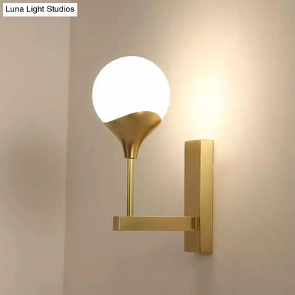 Modern brass wall lamp with gold-toned metal arm and frosted glass shade wall light for bedroom use