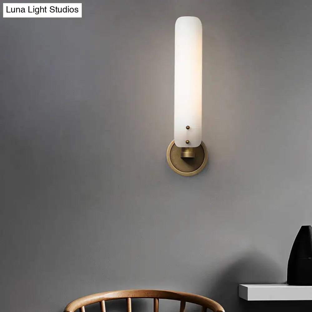 Modern brass wall lamp with opal glass shade and frosted glass sconce featuring a brass-finished base and decorative dots