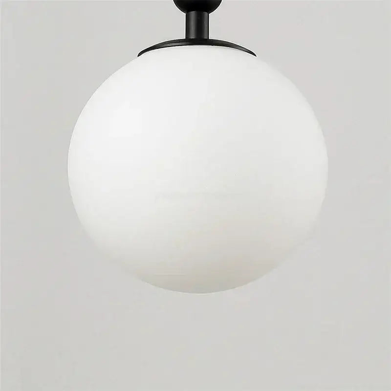 Modern brass wall lights featuring a sleek matte black spherical pendant with a frosted white glass globe decorbites glass ball