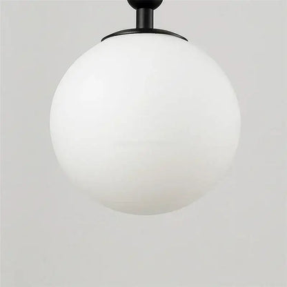 Modern brass wall lights featuring a sleek matte black spherical pendant with a frosted white glass globe decorbites glass ball