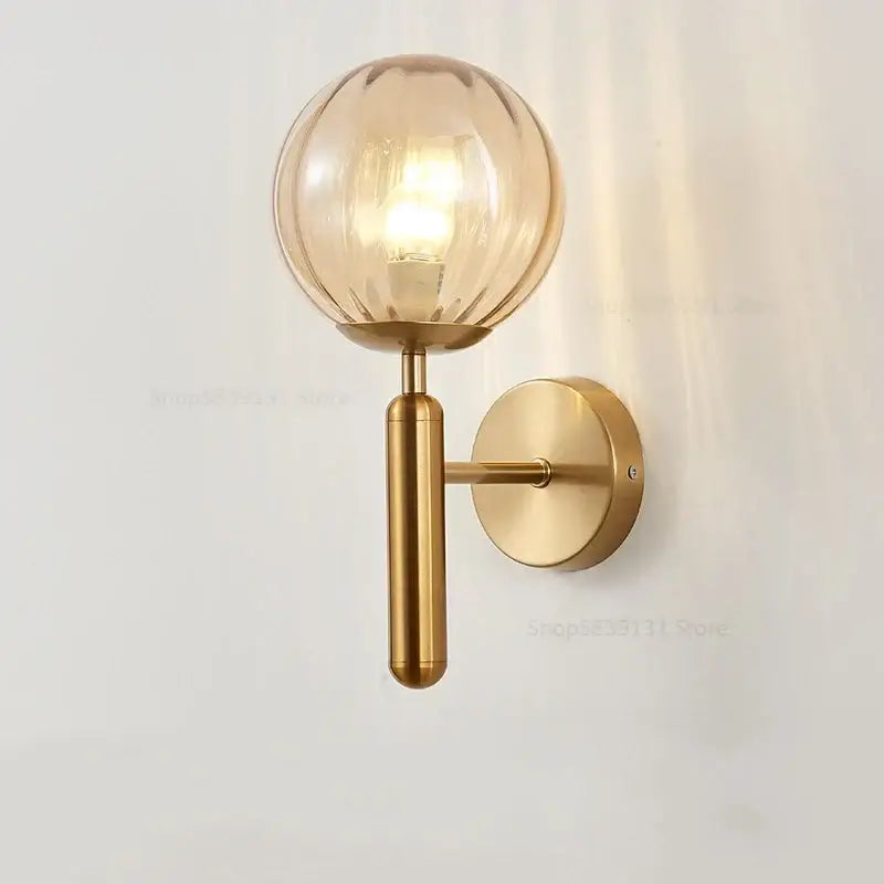 Modern brass wall lights featuring a gold-toned spherical glass globe with ribbed texture and brushed brass finish by decorbites glass ball
