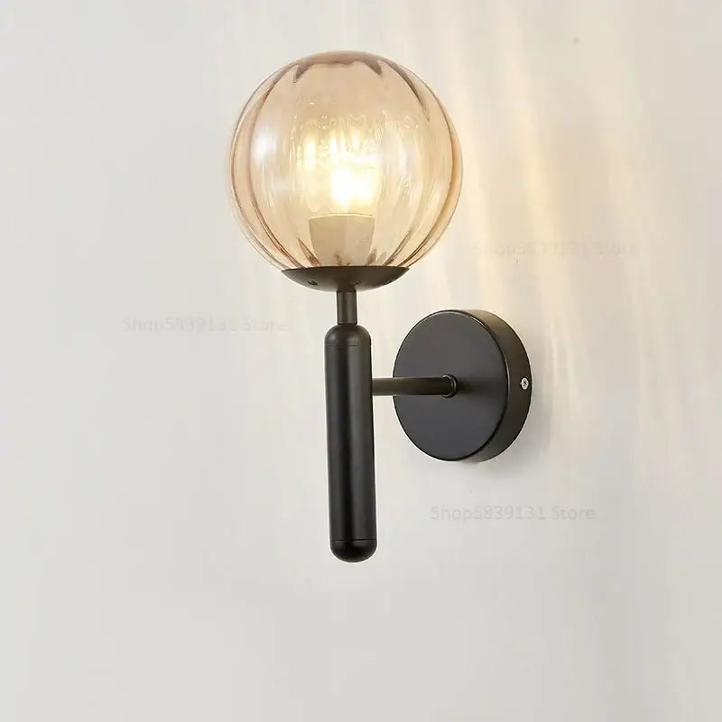 Modern brass wall lights featuring a sleek black metal sconce with a warm amber decorbites glass ball for living room decor