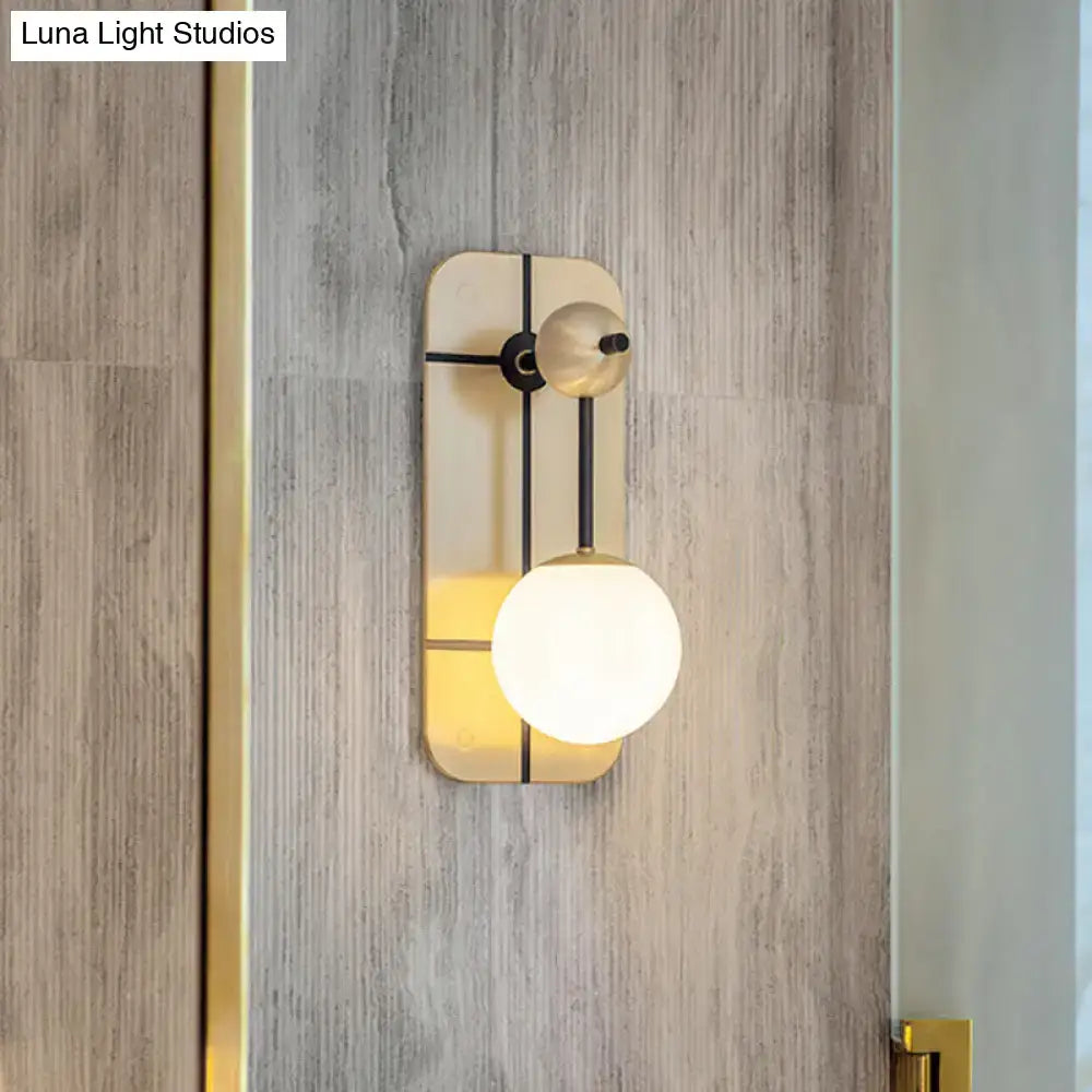 Modern brass wall opal glass sconce with gold-toned rectangular backplate and direct wired warm light fixture