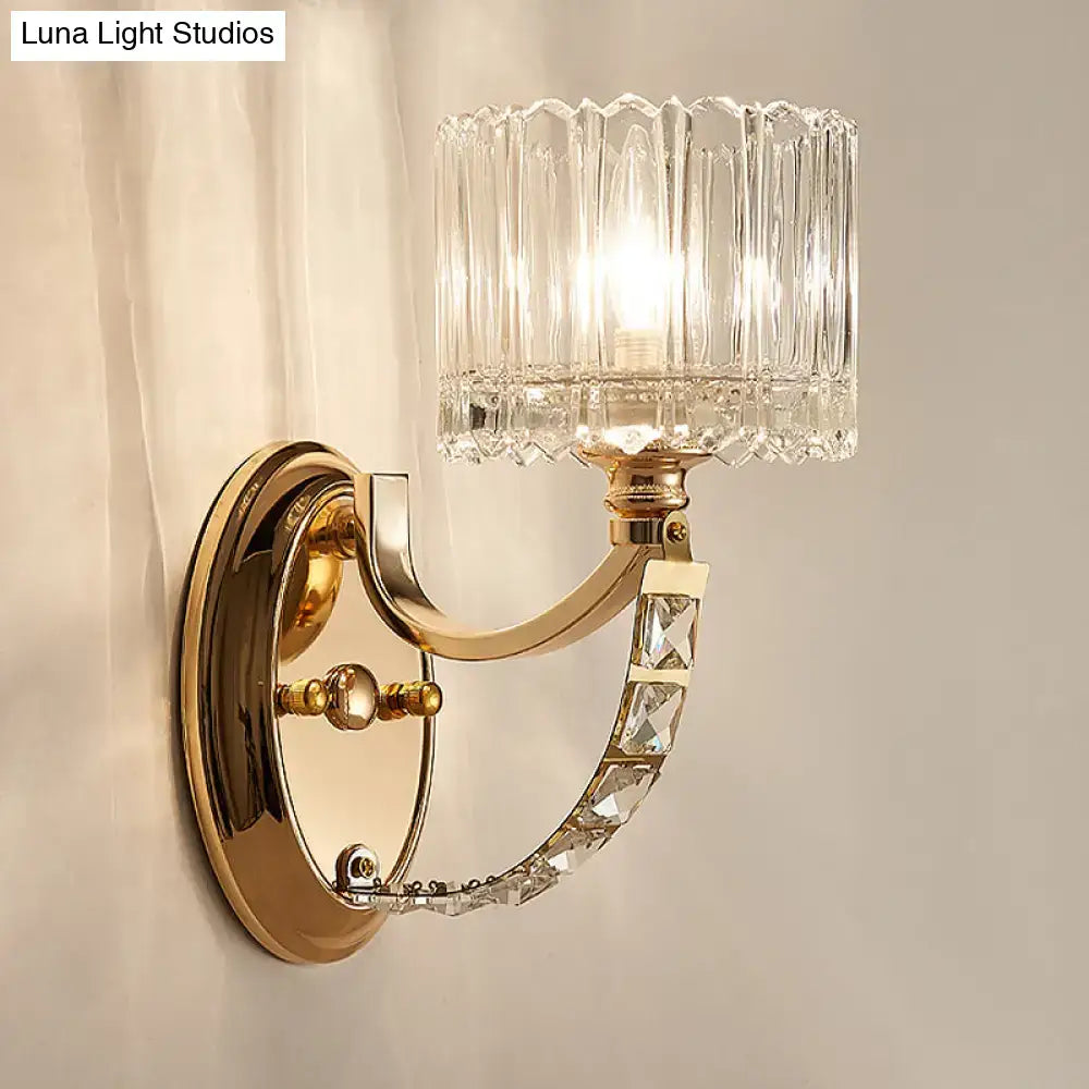 Elegant modern brass wall sconce with gold tone and faceted clear glass shade for stylish bedroom lighting