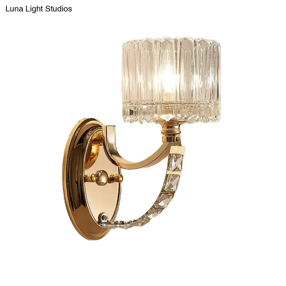 Modern brass wall sconce with gold tone, decorative crystals, and a faceted clear glass shade for bedroom lighting