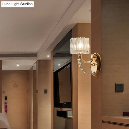 Elegant modern brass wall sconce with a gold-finished metal base and clear glass shade for bedroom lighting