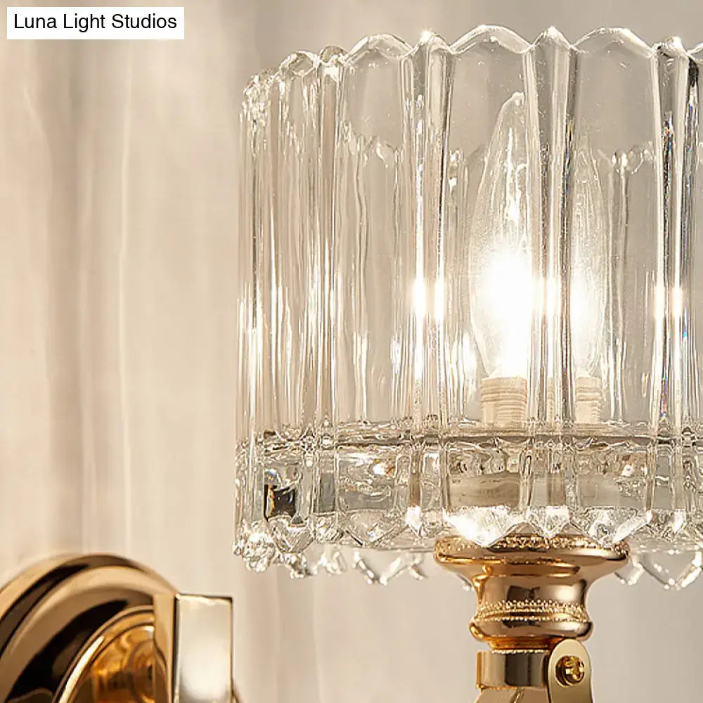 Modern brass wall sconce bedroom light with a clear glass shade and gold-toned faceted glass shade base