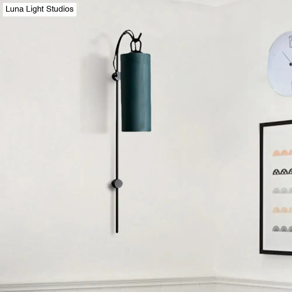 Dark teal cylindrical wall sconce with sleek black metal arm and decorative toggle for direct wired electric 220v-240v use