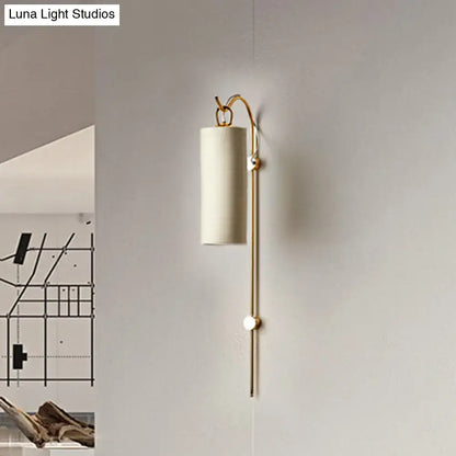 Modern brass and white wall sconce with cylindrical fabric shade and curved arm direct wired electric 220v-240v