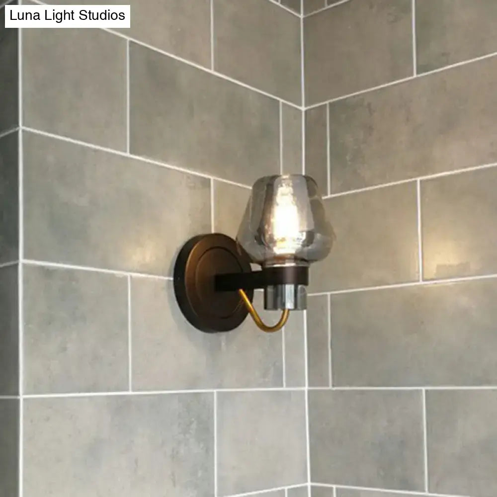A modern bronze and brass smoke gray wall lamp with a brushed brass sconce and mercury glass shade for porch lighting