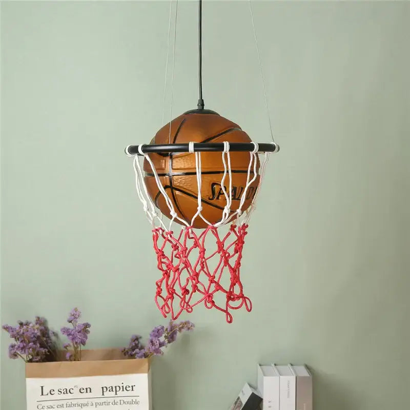 Modern brown basketball pendant lights feature a brown Spalding ball suspended in a white and red net for kids room decor