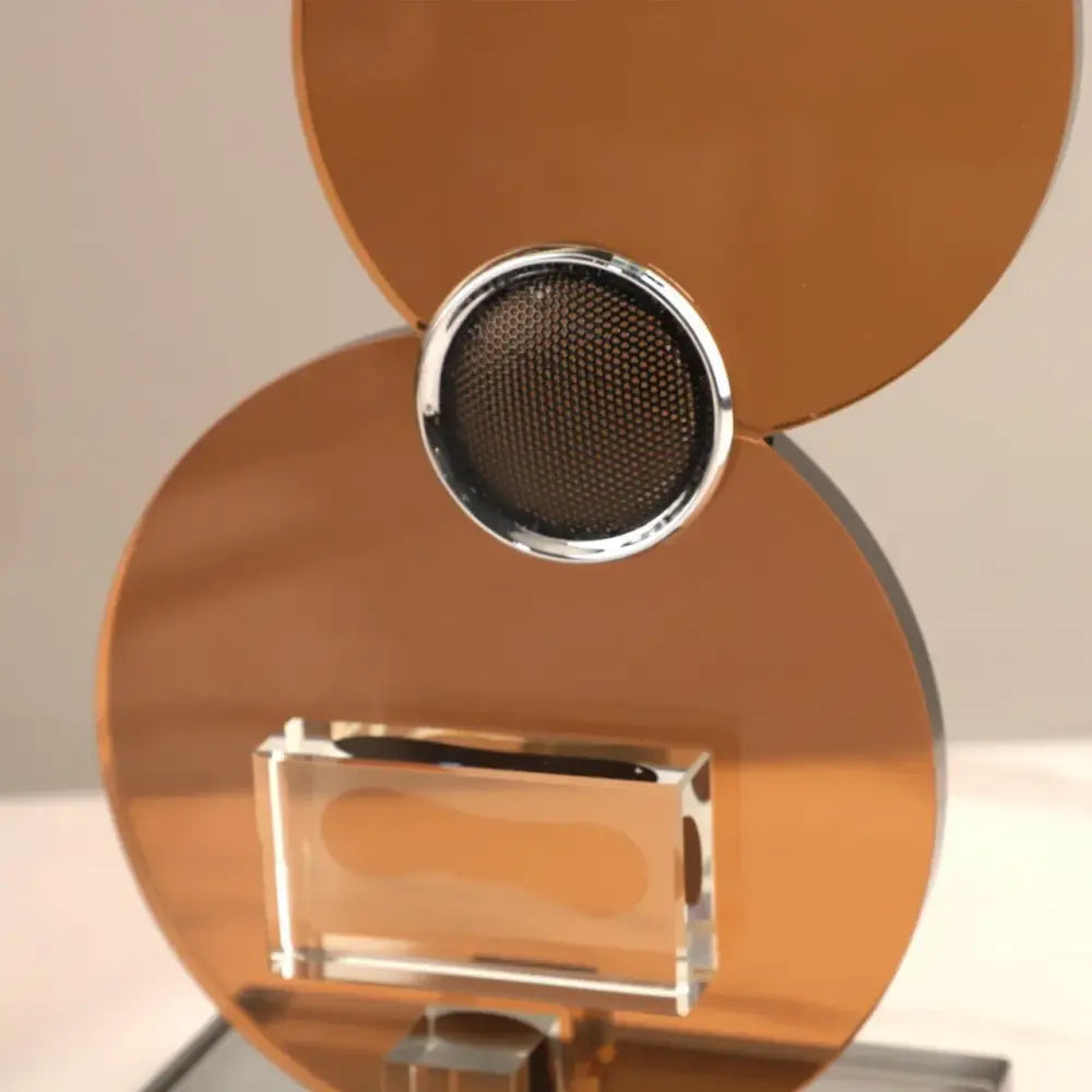Modern brown decorbites crystal guitar sculpture with copper-toned speaker and chrome rim on acrylic base for living room decor