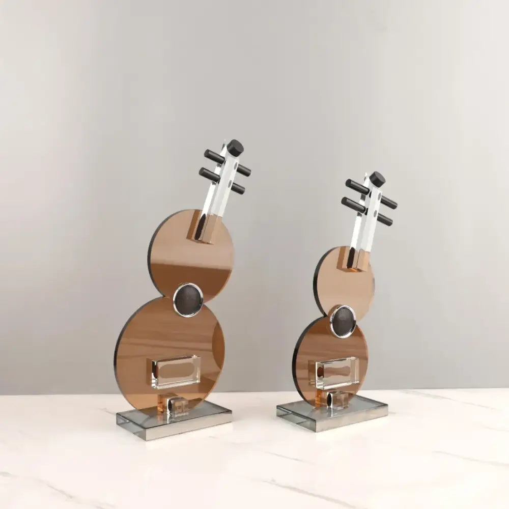 Pair of modern copper-toned glass violin sculptures with chrome accents and clear crystal inlays for decorbites crystal guitar decor