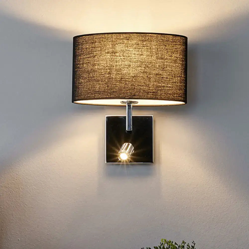 A modern wall light with a textured brown fabric shade and chrome finished square base for bedroom sconce use