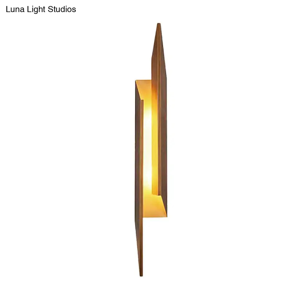 Modern brown geometric metal shade wall sconce with warm amber glow and sleek direct wired electric frame for living room light
