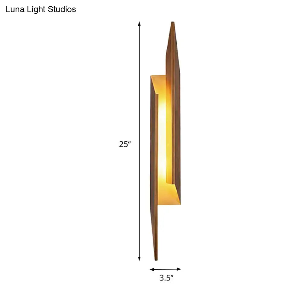 Modern brown geometric metal shade wall sconce with warm amber glow crafted from dark wood and direct wired electric design
