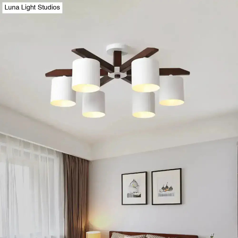 Modern brown and white ceiling mount chandelier with six white cylindrical shades and dark wood arms for living room