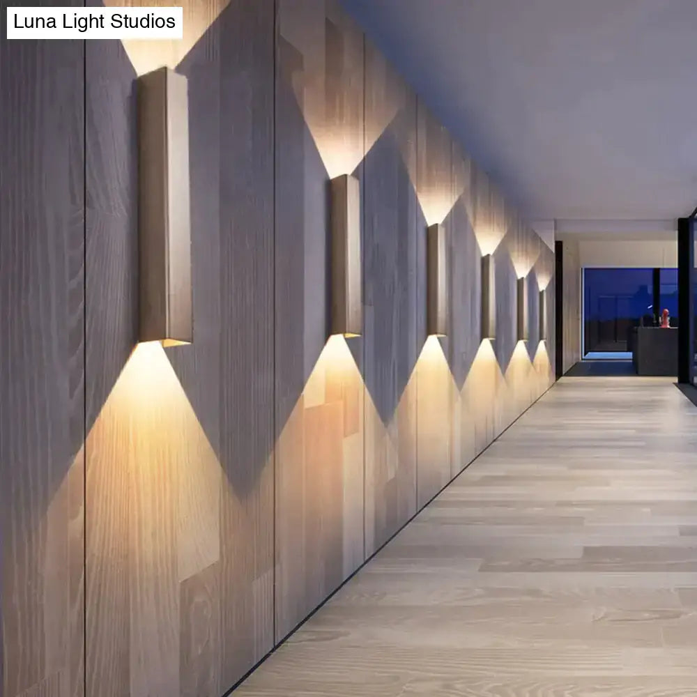 Modern brushed aluminum rectangular wall sconces with warm ambient lighting on wooden paneling for bedroom use