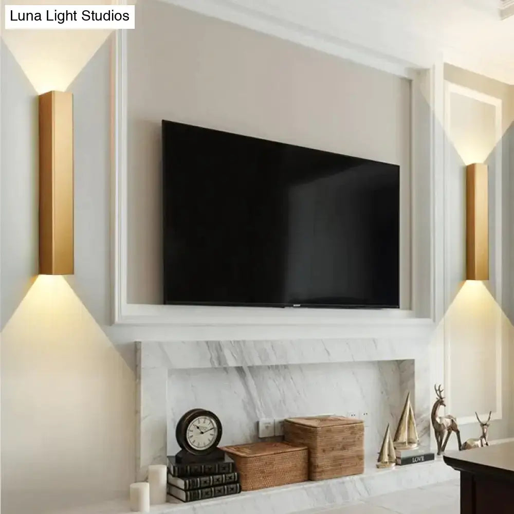 Gold rectangular wall sconces made of brushed aluminum providing warm ambient bedroom lighting