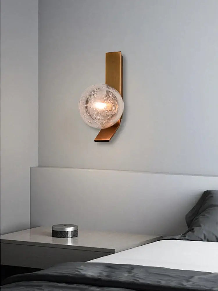 Modern brushed brass wall sconce lamps featuring a gold-toned finish and textured frosted glass globe for bedrooms