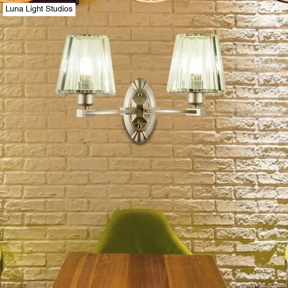 Silver-toned modern wall sconce with two fluted glass shades for a stylish bedroom wall light fixture