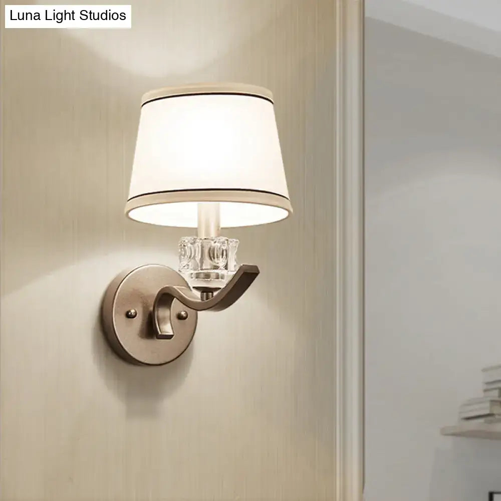 Modern brushed nickel finish wall light with clear crystal accent and white lampshade with black trim sconce light
