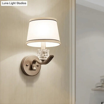 Modern brushed nickel finish wall light with clear crystal accent and white lampshade with black trim sconce light