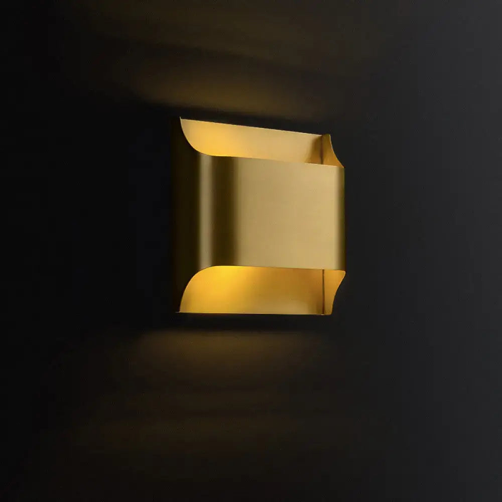 A modern brushed brass flush wall sconce with warm golden curved metallic panels for stairwell wall light use