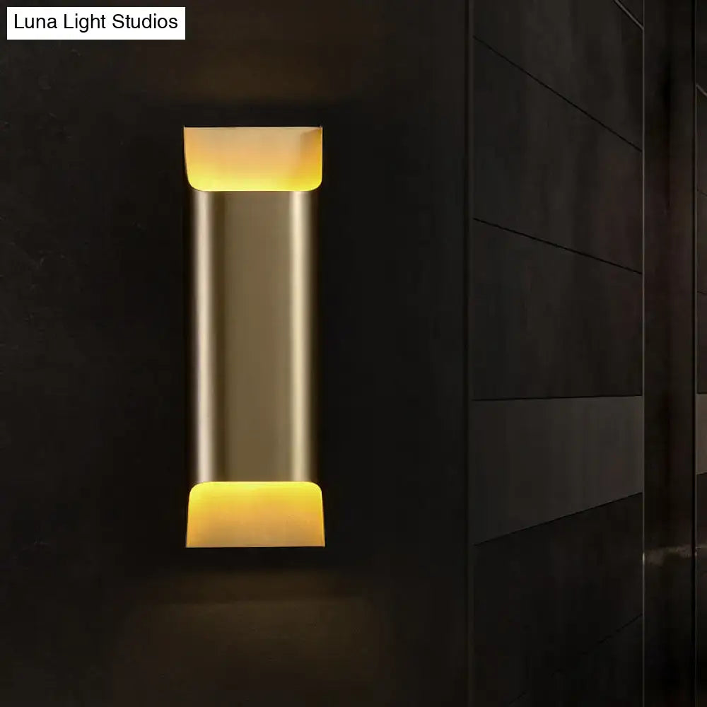 Modern brushed brass flush wall sconce with sleek metallic finish and warm yellow led lighting at both ends