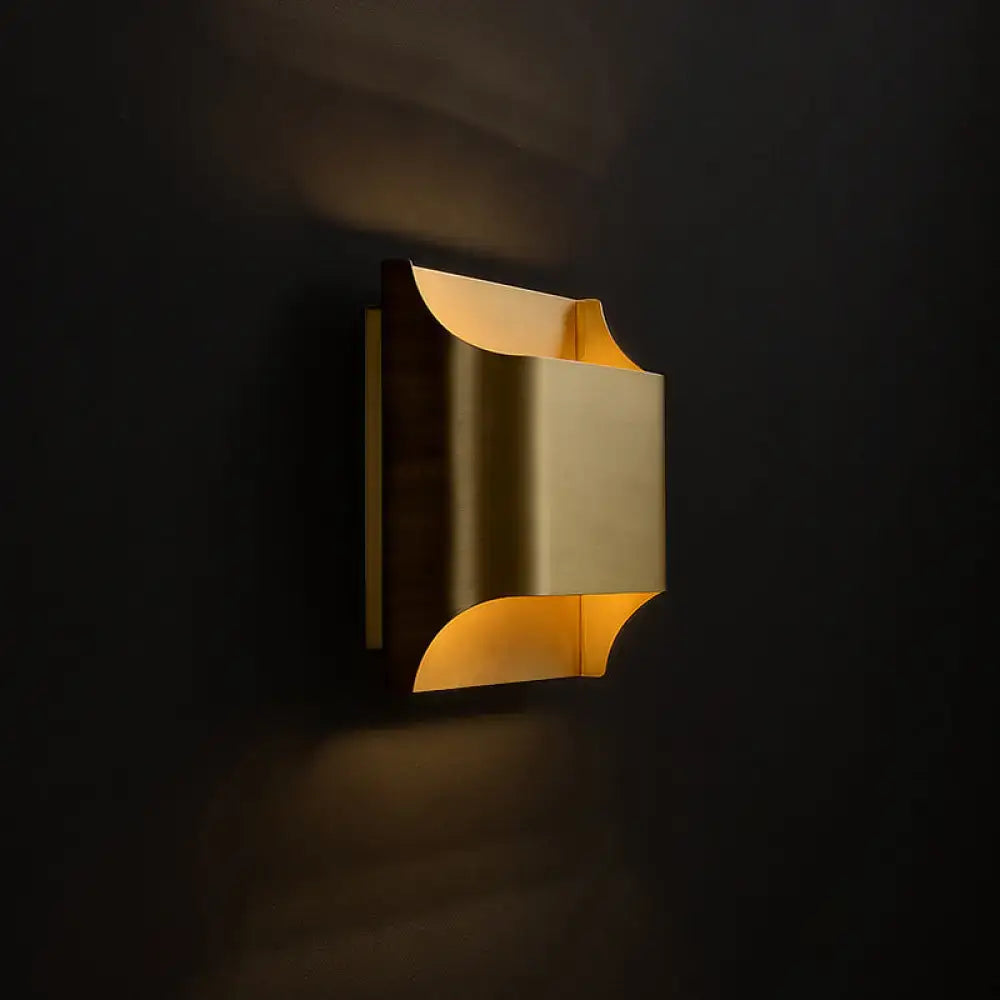 A sleek brushed brass modern flush wall sconce with geometric design casting warm ambient light for stairwells
