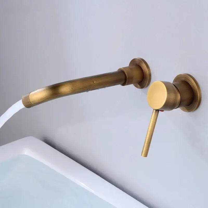 Modern brushed gold and black basin faucet set with brass-finished curved spout and cylindrical handle for bathroom sink