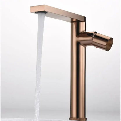 A sleek modern basin faucet with a tall rectangular spout and cylindrical handle in brushed gold decorbites finish