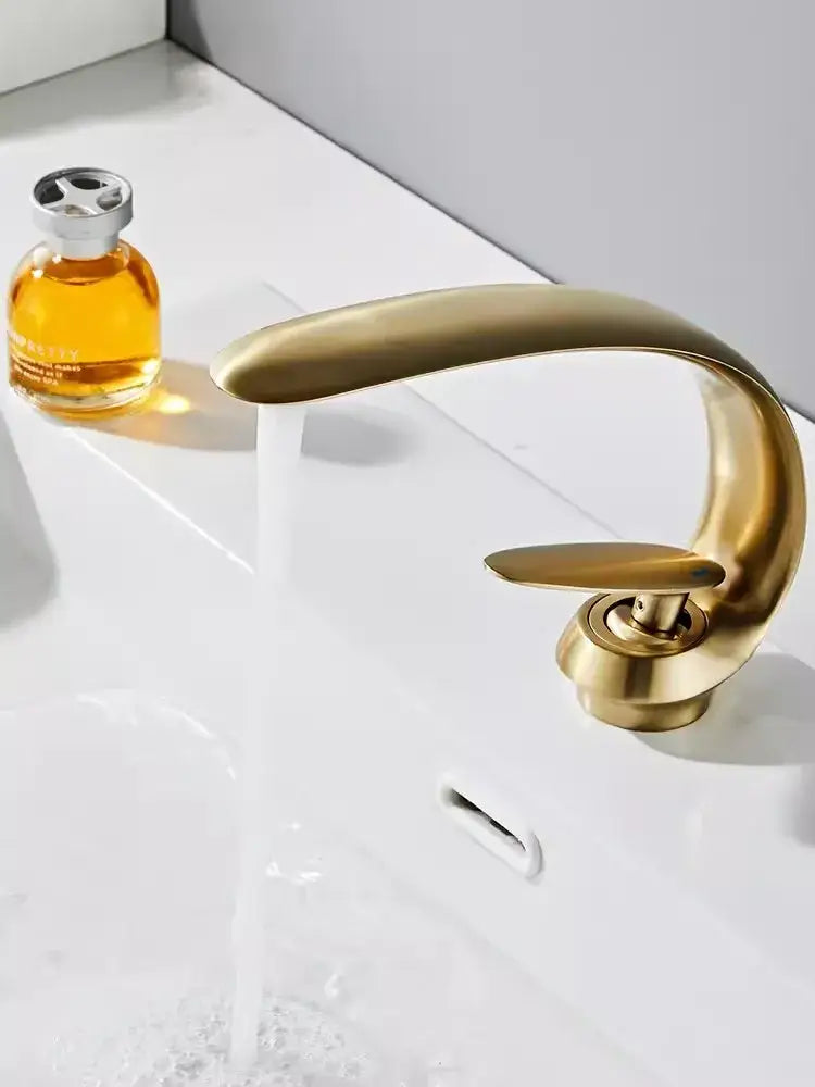 Modern brushed gold basin faucet with a sleek curved spout and single lever handle from decorbites brushed gold collection