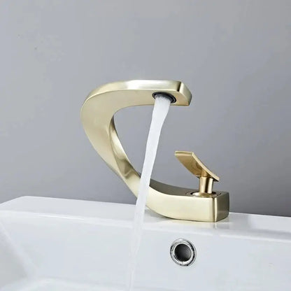 Modern brushed gold basin faucet with sleek curved waterfall design and polished finish by decorbites basin faucet