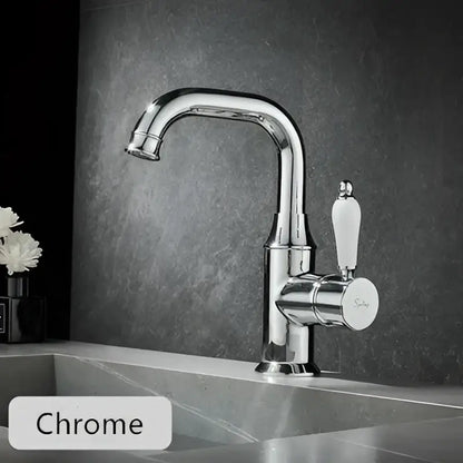 Modern brushed gold basin faucet with chrome finish, sleek curved spout, and white ceramic handle by decorbites