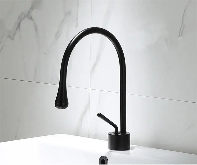 Black matte basin faucet with curved spout and single lever handle complementing decorbites brushed gold style