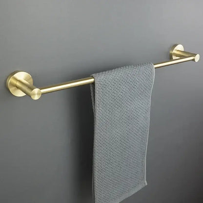 A sleek brushed gold bath hardware set towel rack with matte finish holds a neatly draped gray textured towel