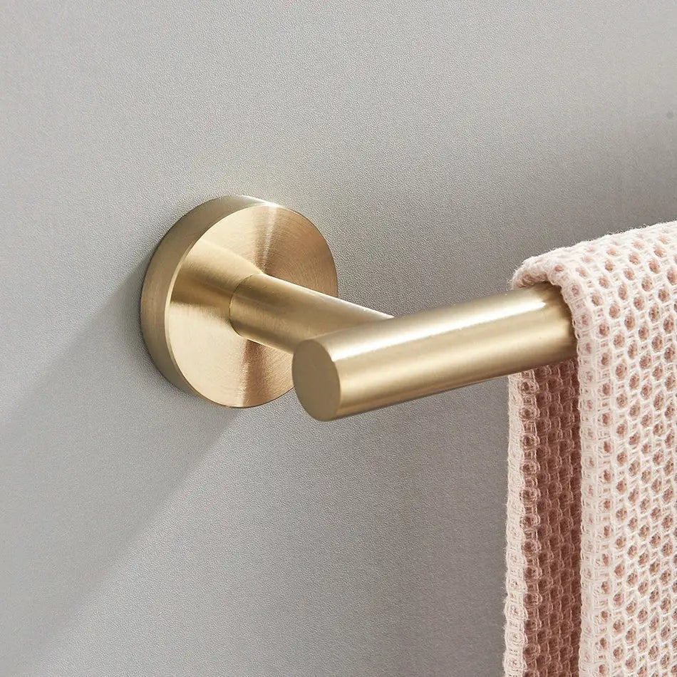 Brass-finished wall-mounted towel rack with sleek cylindrical design in modern decorbites bathroom hardware set