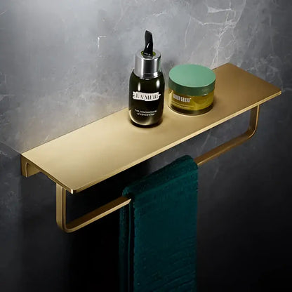 Modern brushed gold brass wall-mounted bath hardware set with integrated towel bar holding la mer bottle and jar