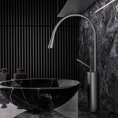 Black marble vessel sink paired with a modern brushed gold brass faucet featuring a sleek matte finish