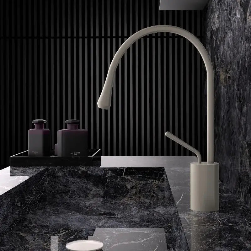 A sleek off-white ceramic kitchen sink faucet with a curved spout and minimalist design in modern brushed gold brass