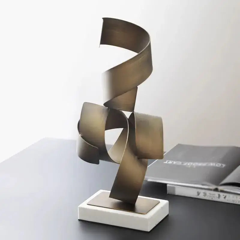 Modern brushed gold geometric wrought iron abstract sculpture with spiral design on white marble base for living room decor