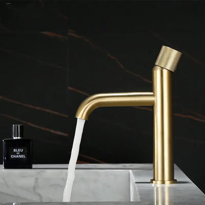 Modern brushed gold single handle basin faucet with a textured knurled handle and sleek cylindrical spout
