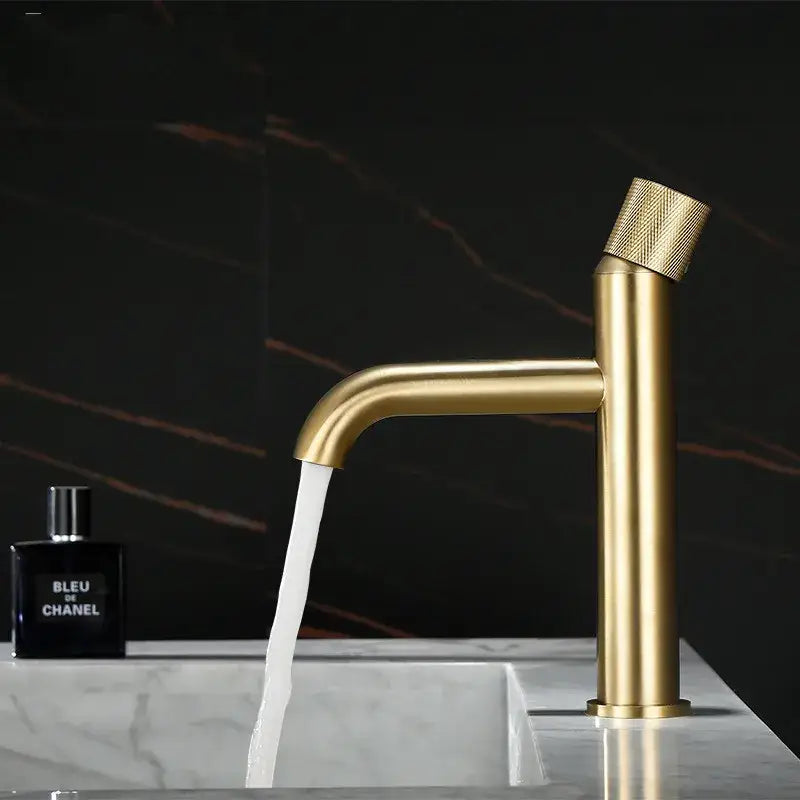 Modern brushed gold single handle basin faucet with a textured knurled handle and sleek cylindrical spout