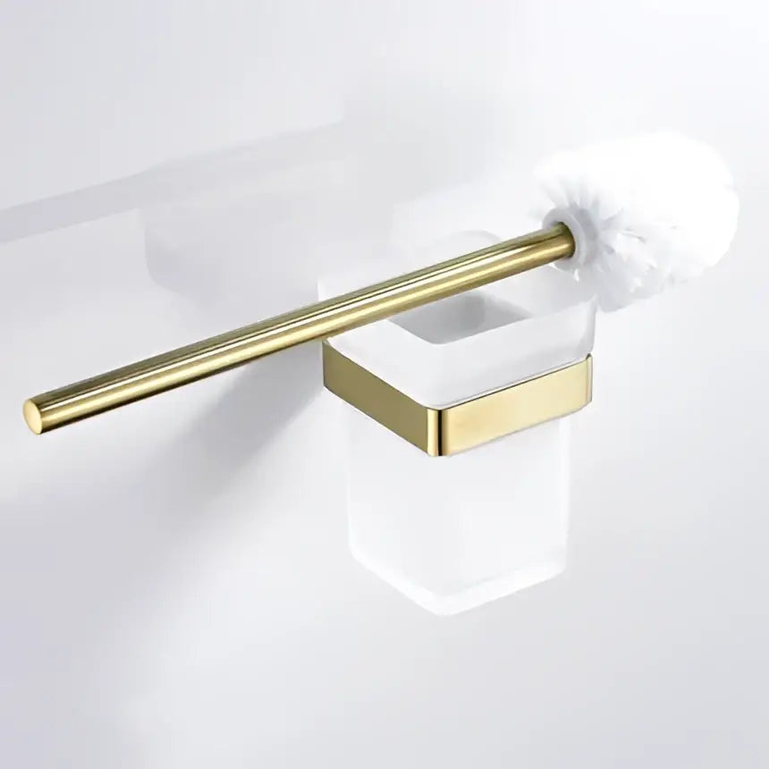 Modern brushed matt gold decorbites bath set featuring a gold-toned toilet brush with white fluffy bristles in a glass holder