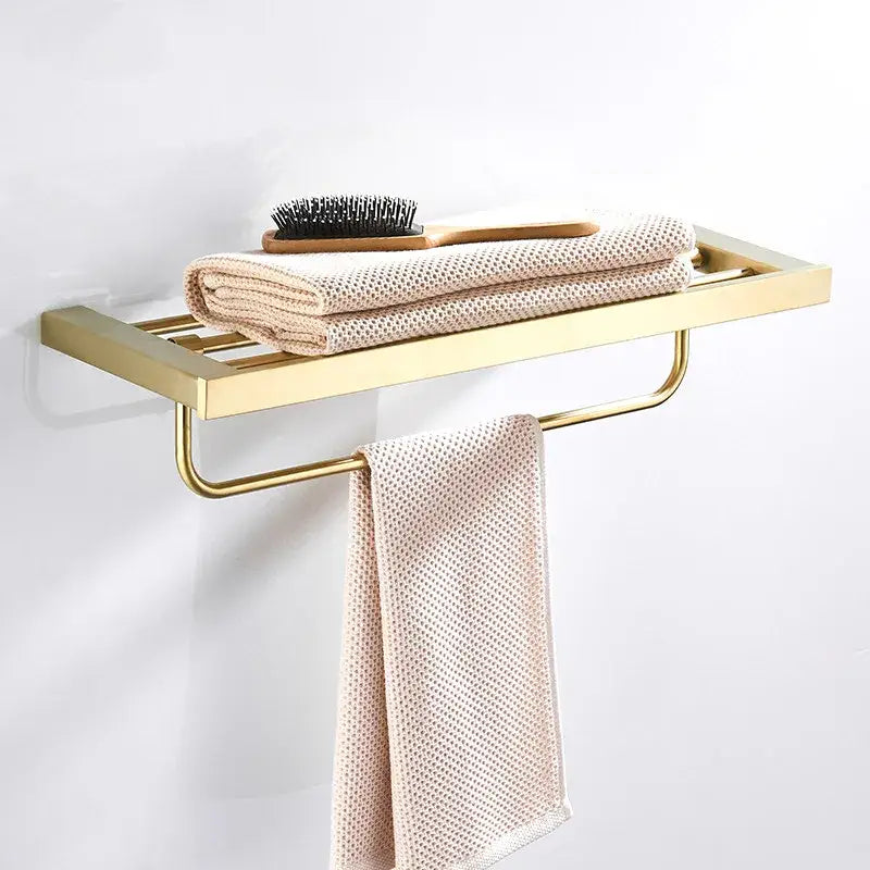 Modern brushed matt gold decorbites bath set metal bathroom rack with flat shelf and towel bar holding beige towels and brush